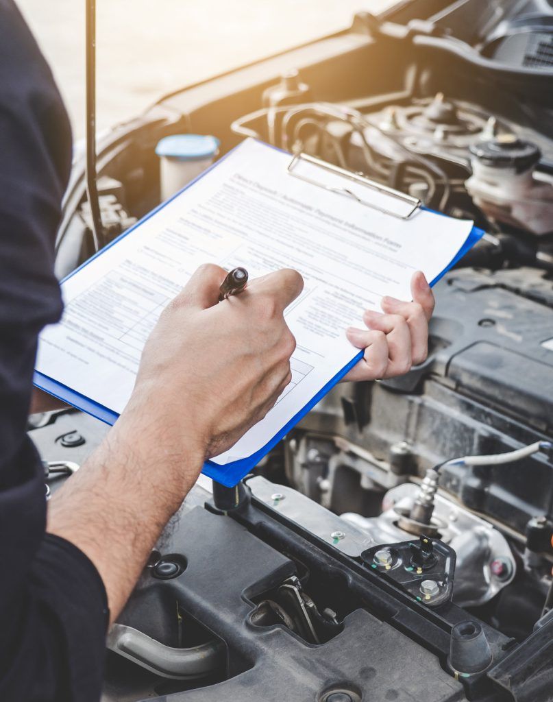 Mechanic checking off a vehicle service list - Vehicle Servicing Northamptonshire